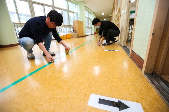 19일 오전 광주광역시 북구 빛고을고등학교 선생님들이 복도에 학생들의 동선을 나누기 위한 우측통행 및 1m거리두기 표시를 하고 있다. 광주-프리랜서 장정필
