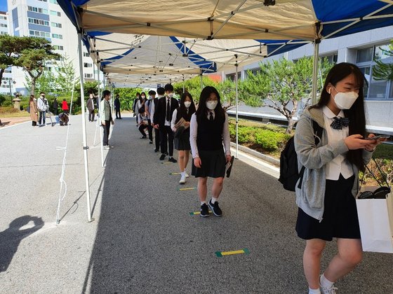고등학교 3학년 등교가 시작된 20일 충북 청주시 상당구 금천고등학교 3학년 학생들이 체온을 재기 위해 1m씩 거리를 두고 줄을 서 있다. 청주-최종권 기자