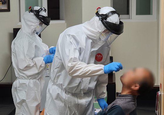 경북 구미시에서 고교생과 시장상인 등이 신종 코로나바이러스 감염증(코로나19) 확진 판정을 받은 가운데 24일 구미 시내 한 임시 선별검사실에서 확진자들과 접촉한 시민이 방역 당국 관계자들로부터 코로나19 검사를 받고 있다. 연합뉴스