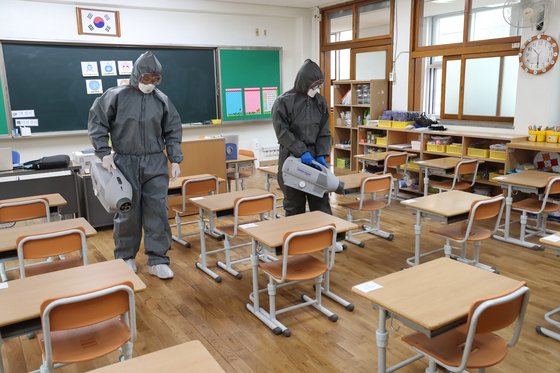 26일 오전 광주 북구의 한 초등학교에서 북구청 방역반원들이 코로나19 방역을 하고 있다. 지난주 고3에 이어 오는 27일에는 유치원과 초등학교 1~2학년, 중학교 3학년, 고등학교 2학년이 각각 등교한다. 연합뉴스