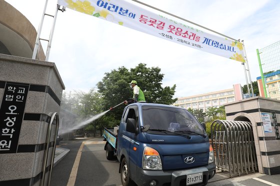 2차 등교 개학 첫날인 27일 오전 대구 수성구 오성고등학교 3학년 학생 1명이 신종 코로나바이러스 감염증(코로나19) 검사에서 확진으로 판명된 가운데 수성구청·수성보건소 방역관계자들이 학교 정문과 진입로 주변에 소독약을 뿌리고 있다. 뉴스1