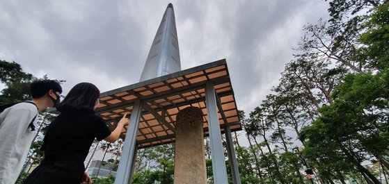 서울 송파구 석촌호수 공원에 세워진 삼전도비(3.95m). 조선시대 청나라에 항복한 굴욕의 역사를 상징한다. 불과 100여m 거리에 롯데월드타워(555m)가 치솟아 있다. 중국몽과 신중화주의를 앞세운 중국은 사드를 핑계 삼아 한국 측에 부당한 보복을 가했다. 사드 기지를 제공한 롯데는 큰 보복을 당했다. 장세정 기자
