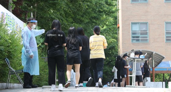 8일 서울 중랑구 원묵고등학교에 마련된 선별진료소에서 학생들이 신종 코로나바이러스 감염증(코로나19) 검사를 받기 위해 손 소독을 한 뒤 이동하고 있다. 이 학교 3학년 학생 1명이 '롯데월드'를 방문했다가 신종 코로나바이러스 감염증(코로나19) 확진 판정을 받았다. 뉴스1
