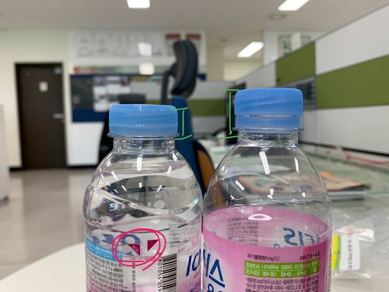 과거 페트병보다 뚜껑의 플라스틱 함량을 줄이고 재활용이 쉽도록 라벨을 한 번에 뗄 수 있게 만든 '경량화 페트병'(사진 왼쪽).