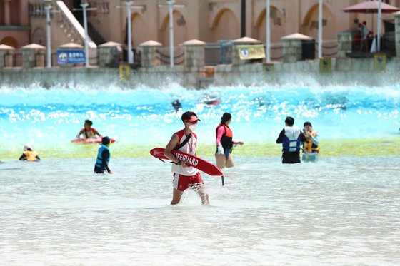 무더위에 워터파크를 찾은 피서객들의 모습. 코로나19의 여파로 '물 반 사람 반'이던 예년의 풍경은 사라졌다. 마스크를 착용한 안전요원의 모습도 아직은 낯설다. 캐리비안 베이는 입장 인원을 하루 1200명으로 제한하고 있다. [사진 에버랜드]