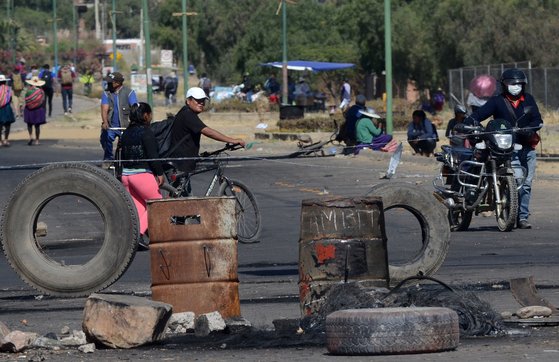 지난달 18일 볼리비아 코차밤바 남부 카라카라 지역에서 좌파인 에보 모랄레스 전 대통령을 지지하는 사람들이 타이어와 철책으로 바리케이드를 치고 정부 관계자 등 외부인이 들어오지 못하게 가로막고 있다. 코로나19 사태로 볼리비아 등 남미 각국의 정국 상황이 불안해지고 있다. [AFP=연합뉴스]