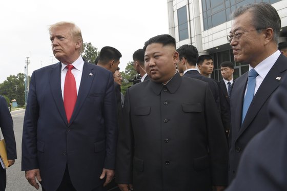 도널드 트럼프 미국 대통령(오른쪽)과 김정은 북한 국무위원장(가운데), 문재인 대통령이 지난해 6월 30일 판문점 남측 지역에서 함께 사진 촬영을 하고 있다. 존 볼턴 전 보좌관은 회고록에서 "북한은 물론 미국도 문 대통령이 참여하는 것을 원치 않았다"라고 공개했다.[AP=연합뉴스]