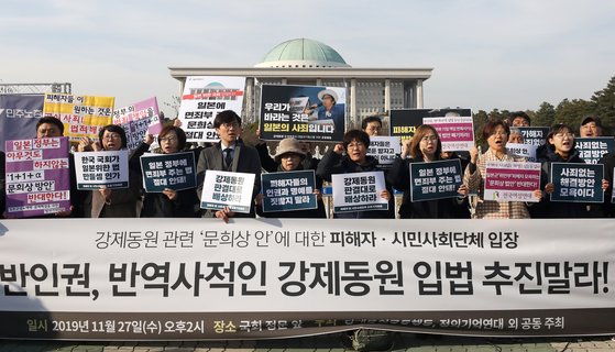 지난해 11월 27일 오후 서울 여의도 국회 앞에서 열린 '일본군위안부-강제징용 문희상 안에 대한 피해자 시민사회단체 공동 기자회견'에서 참가자들이 구호를 외치고 있다. [뉴스1]