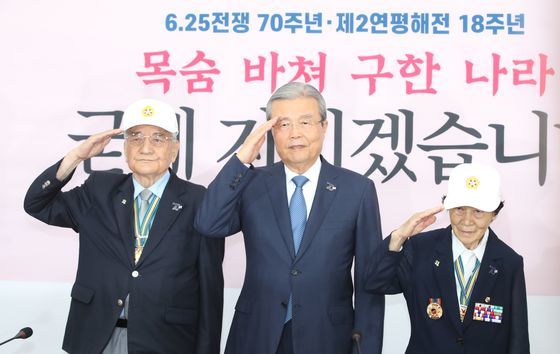 김종인 미래통합당 비상대책위원장이 22일 서울 여의도 국회에서 류연갑 대한민국 6ㆍ25 참전유공자회 기념사업국장, 박옥선 대한민국 6ㆍ25 참전유공자회 서울지부 종로구지회장에게 호국영웅배지를 수여한 뒤 거수경례하고 있다. [중앙포토]