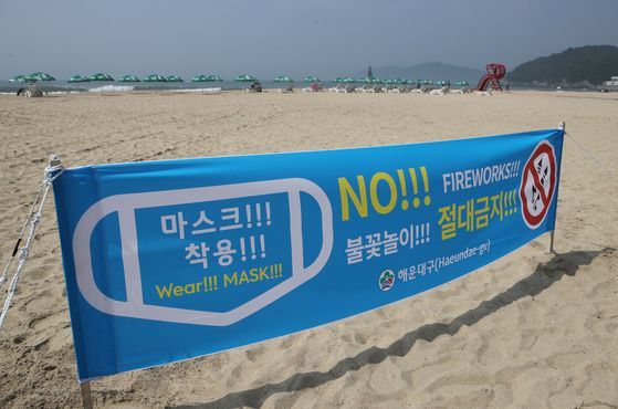 최근 외국인들이 부산 해운대해수욕장에서 마스크를 하지 않은 채 불꽃놀이를 하는 등 소동을 벌이자 8일 부산 해운대해수욕장에 마스크를 착용하자는 안내 현수막이 설치 돼 있다. 송봉근 기자