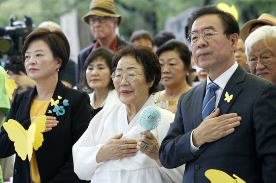 지난해 3·1운동 100주년 기념 일본군 '위안부' 피해자 기림의 날 기념행사에서 진선미 여성가족부 장관(앞줄 왼쪽부터), 위안부 피해자 이용수 할머니, 박원순 서울시장이 국민의례를 하고 있다. 뉴스1