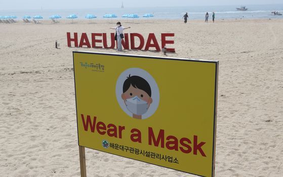 최근 외국인들이 부산 해운대해수욕장에서 마스크를 하지 않은 채 불꽃놀이를 하는 등 소동을 벌이자 8일 부산 해운대해수욕장에 마스크를 착용하자는 영자 안내문이 설치 돼 있다. 송봉근 기자