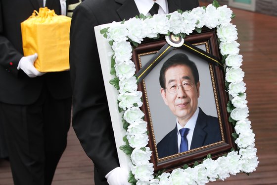지난 13일 고(故) 박원순 서울시장의 영정과 유골함이 서울 서초구 서울추모공원에서 화장을 마친 뒤 박 시장의 고향인 경남 창녕으로 이동하기 위해 운구차로 향하고 있다. [연합뉴스]