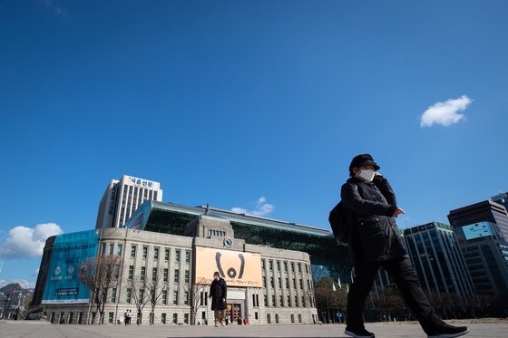 미세먼지 농도가 '좋음'을 보인 지난 2월 27일 서울광장에서 푸른 하늘 아래 마스크를 쓴 시민들이 지나고 있다. 뉴스1