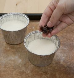 6. 은박지로 된 컵에 반죽을 2/3정도만 채우고 건포도를 얹는다.