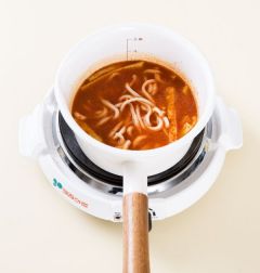 4. 불을 세게 올리고 우동을 넣어 2~3분 정도 끓이다가 대파를 넣는다. 그릇에 담고 깻잎을 뿌린다.