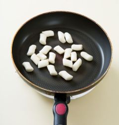 2. 팬에 식용유를 넉넉히 두르고 가래떡을 넣어 노릇노릇하게 지진다.