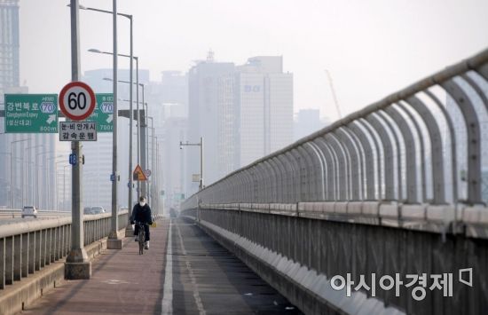 중서부 지역 미세먼지 농도가 '나쁨' 수준을 보인 15일 서울 마포대교에서 마스크를 쓴 시민이 자전거를 타고 있다. /문호남 기자 munonam@