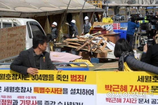 참사 진상규명과 책임자 처벌을 요구하는 피켓을 든 유족들이 고개를 돌려 철거되는 천막을 바라보고 있다. /문호남 기자 munonam@