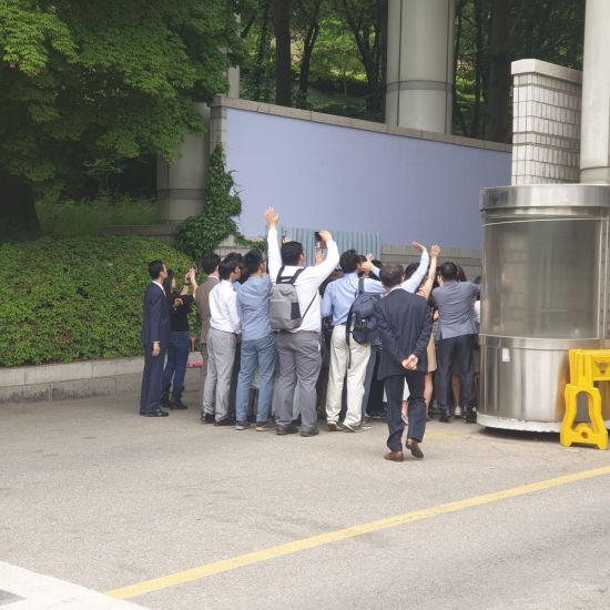 '신도 성폭행' 혐의로 2심에서 징역 16년을 선고받은 이재록 만민교회 목사가 탄 호송차를 보며 만민교회 신도들이 손을 흔들고 있다./190517 이기민 기자 victor.lee@