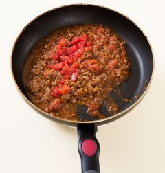 2. 미트 소스를 만든다. 팬에 식용유를 두르고 다진 마늘과 다진 쇠고기를 3분 정도 중간 불에 볶다가 토마토 소스를 넣어 걸쭉하게 끓인다. 토마토는 씨를 배고 굵게 다져 넣고 소금과 후춧가루로 간을 한다.