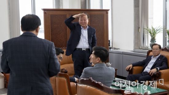 김재원 국회 예결위원장(가운데)이 1일 국회 예결위원장실에서 열린 예결위 간사 간담회에 참석하는 윤후덕 더불어민주당 간사에게 거수 경례로 인사를 하고 있다./윤동주 기자 doso7@