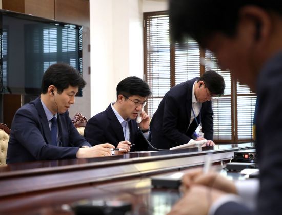 지난해 4월 20일 송인배 당시 대통령 제1부속비서관이 청와대에 설치된 남북 정상 간 직통 전화 통화 상태를 확인하기 위해 북한 국무위원회 담당자와 시험 통화를 하고 있다. 왼쪽은 윤건영 국정기획상황실장. 
사진=청와대