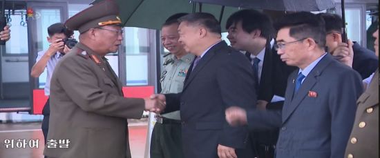 북한 인민군의 김수길 총정치국장이 이끄는 군사대표단이 16일 중국을 방문하기 위해 평양을 출발했다고 조선중앙TV가 보도했다. 김수길 총정치국장(왼쪽)이 평양 국제공항에 배웅하러 온 리진쥔(李進軍) 주북 중국대사(중앙)와 악수하고 있다.