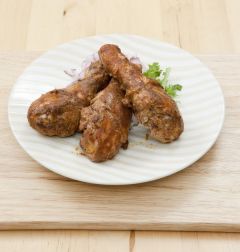 6. 접시에 채썬 양파와 구운 닭다리를 먹음직스럽게 담고 땅콩버터 소스를 곁들인다.