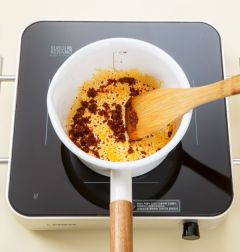 2. 냄비를 달구어 고추기름을 두르고 고춧가루를 넣어 중간 불에서 고춧가루가 타지 않도록 볶다가 다진 마늘을 볶는다.