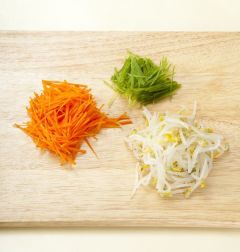 3. 숙주는 머리와 꼬리를 떼어내어 끓는 물에 소금을 넣어 2분 정도 데쳐 물기를 뺀 다음 소금으로 간을 한다. 당근은 가늘게 채 썰고 오이는 돌려깍기 하여 가늘게 채 썬다.