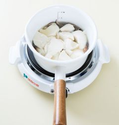 4. 모시조개 입이 벌어지면 순두부를 숟가락으로 떠 넣는다. 다진 마늘을 넣고 새우젓으로 간을 맞춘다.