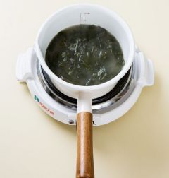4. 나머지 물 2컵을 넣고 미역이 부드러워질 때까지 센 불로 10분 정도 더 끓인다. 다진 파와 다진 마늘을 넣고 소금과 후춧가루로 간을 한다.