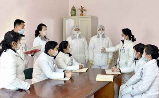 노동당 기관지 노동신문이 10일 보도한 사진으로, 북한 대동강구역 청류종합진료소에서 관계자들이 방호복과 마스크 등을 착용하고 이야기를 나누는 모습.