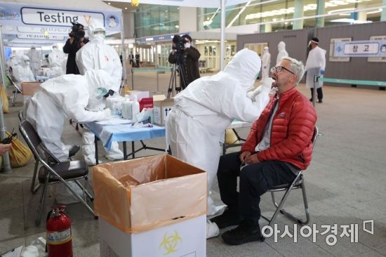 26일 인천국제공항 2터미널 옥외공간에 마련된 개방형 선별진료소(오픈 워킹스루형·Open Walking Thru)에서 영국 런던발 여객기를 타고 입국한 무증상 외국인이 코로나19 진단 검사를 받고 있다. /문호남 기자 munonam@