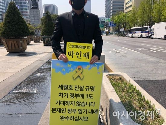 16일 서울 광화문광장 일대에서 진행된 '세월호 6주기 추모 1인 피켓 시위'에 참여한 한 시민이 세월호 진상 규명을 촉구하는 내용의 피켓을 들고 있다.사진=김연주 인턴기자 yeonju1853@