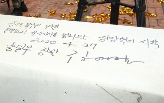 27일 강원 고성군 제진역에서 열린 동해북부선 추진 기념식에서 김연철 통일부 장관이 침목에 서명한 내용. 
    '동해북부선 연결, 한반도와 유라시아를 넘나드는 상상력의 시작'이라는 문장이 적혀있다.