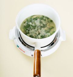 4. 중간중간 바닥에 눌어붙지 않도록 저어가며 끓이다가 쌀알이 퍼지면 냉이를 넣고 3분 정도 더 끓인다. 소금으로 간을 하고 깨소금을 넣는다.