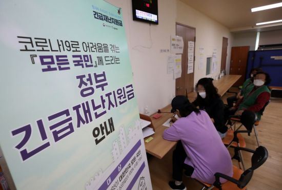 긴급재난지원금 오프라인 신청 접수 첫날인 18일 서울 송파구 삼전동 주민센터에서 시민들이 지원금 신청서를 작성하고 있다/사진=연합뉴스