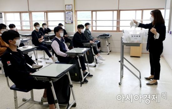 신종 코로나바이러스 감염증(코로나19) 사태로 미뤄진 등교수업이 재개된 20일 서울의 한 고등학교에서 3학년 학생들이 담임 선생님에게 방역 물품에 대한 설명을 듣고 있다. /문호남 기자 munonam@