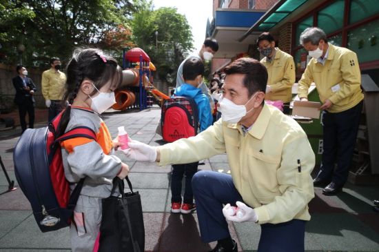 이강덕 포항시장이 27일 이동한빛유치원 앞에서 등교 어린이들에게 손소독제를 나눠주고 있는 모습.