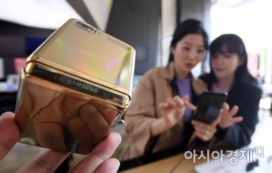삼성전자가 갤럭시Z플립의 인기를 이어가기 위해 6일 미러 골드 모델을 새롭게 출시했다. 미러 골드는 지난 2월 미국 샌프란시스코에서 열린 갤럭시 언팩 행사에서 모습을 드러냈지만 국내에선 판매되지 않았다. 중국과 인도, 싱가포르 등 일부 국가에서만 출시된 뒤 이번에 국내에서도 첫 선을 보였다. 사진은 이날 서울 광화문 KT스퀘어에 전시된 갤럭시Z플립 미러 골드 모델 모습./김현민 기자 kimhyun81@