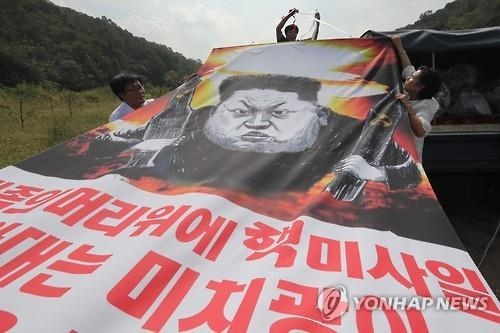 2016년 9월15일 경기 파주시 낙하 IC 인근에서 자유북한운동연합 회원들이 북한 핵실험을 규탄하는 대형 플래카드를 날리기 위해 준비하고 있다. [이미지출처=연합뉴스]