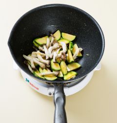 2. 팬을 달구어 식용유를 두르고 애호박, 느타리버섯, 다진 마늘을 넣어 3분 정도 볶다가 양파를 넣고 1분 정도 더 볶는다.