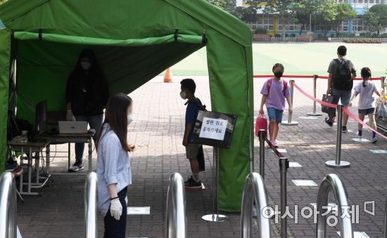 중1과 초 5, 6년 학생들의 4차 등교 수업이 시작된 8일 서울의 한 초등학교에서 학생들이 교문에서 발열검사를 받고 있다. 교육부에 따르면 이날 등교에 나서는 중1과 초 5, 6년 학생은 135만 명으로 당초 개학일인 올 3월 2일 이후 98일 만이다. 앞서 고3이 지난달 20일 처음 등교에 나섰고, 이후 학년별로 순차 등교를 진행했다. 이날 등교를 끝으로 전국 595만 초중고생들이 올해 1학기 등교 수업에 들어가게 됐다./김현민 기자 kimhyun81@