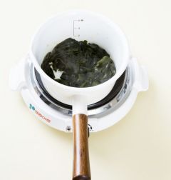 3. 냄비에 미역을 넣어 2분 정도 볶다가 물 4컵을 넣어 센 불로 끓인다. 국물이 끓기 시작하면 중간 불로 줄여서 10분 정도 끓인다.