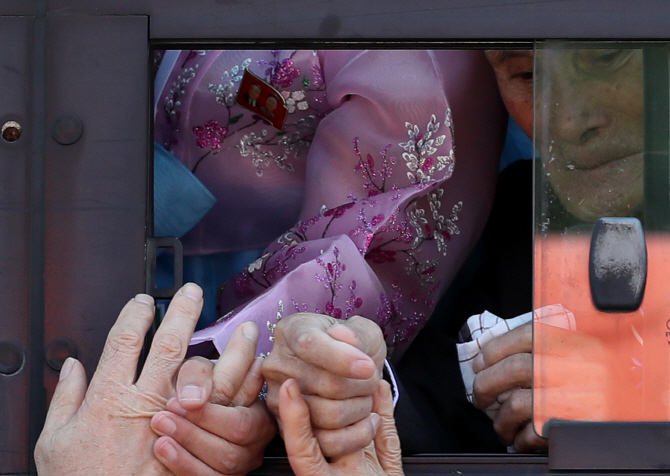 제21차 이산가족 상봉행사 2회차 마지막날인 지난해 8월 26일 오후 금강산호텔에서 열린 작별상봉 및 공동중식을 마친 이산가족이 손을 잡고 작별인사를 나누고 있다. (사진=연합뉴스)