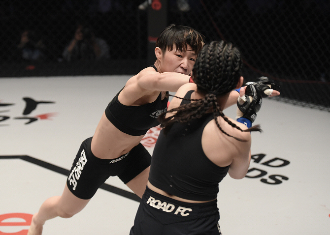박정은(왼쪽)이 로드FC 대회에서 김은혜에게 라이트 펀치를 날리고 있다. 사진=로드FC