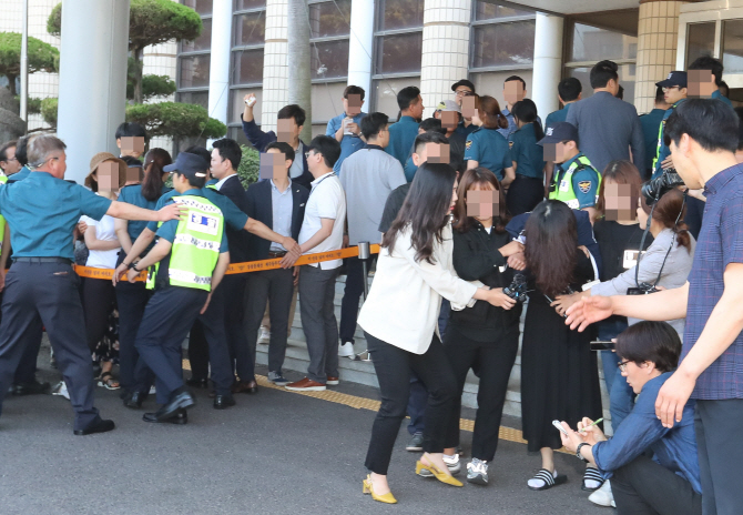 ‘제주 전 남편 살해 사건’ 피의자 고유정이 12일 제주동부경찰서에서 제주지검으로 송치되며 피해자 가족들의 항의를 받고 있다. (사진=뉴시스)