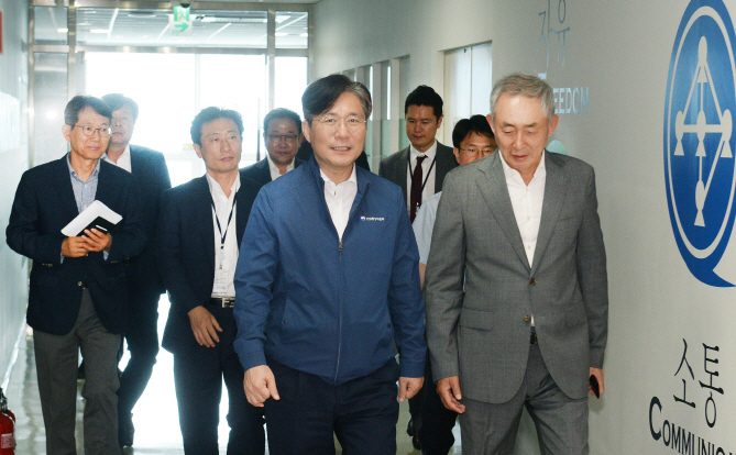 성윤모 산업통상자원부 장관(앞줄 왼쪽)과 이용한 원익그룹 회장(앞줄 오른쪽)이 지난달 30일 반도체 장비기업인 원익IPS 경기도 평택 사업장에서 사업장을 둘러보며 이야기를 나누고 있다. 산업부 제공